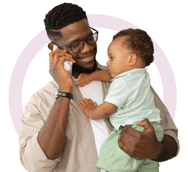 A father holds a baby and talks on the phone