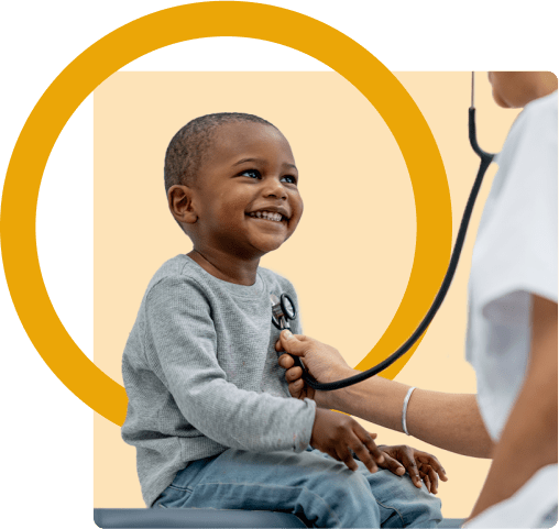 A doctor listens to a small boy's heart with a stethoscope